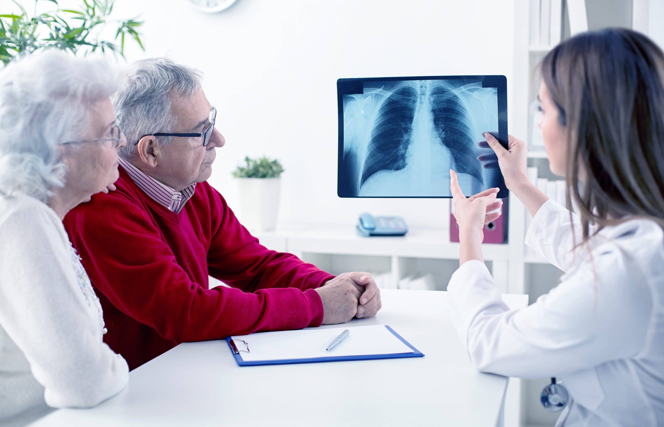 This is an image of a doctor diagnosing a patient with lung cancer via scan imagery.