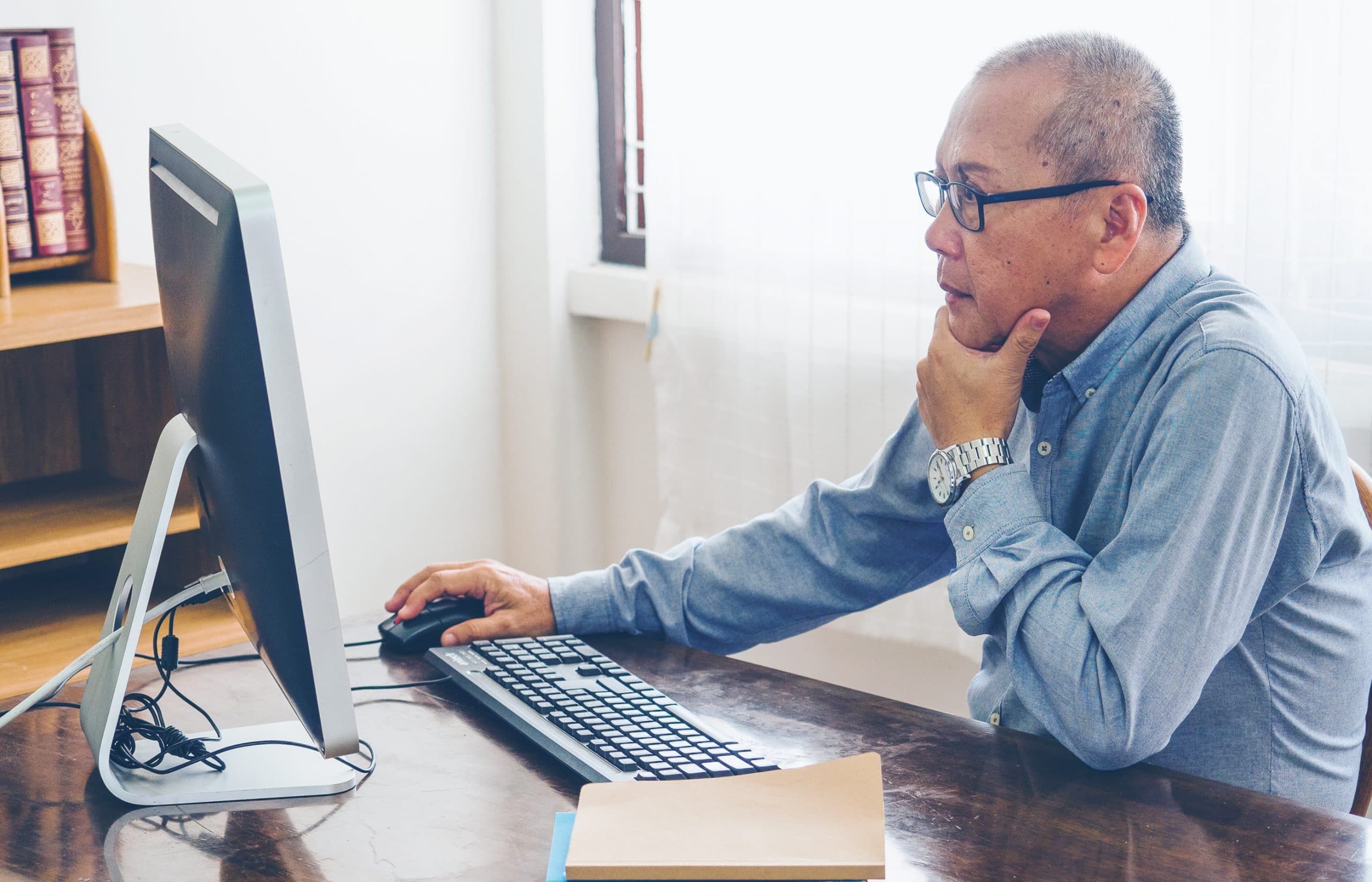 This is an image of a man utilizing his resources to learn more about lung cancer.