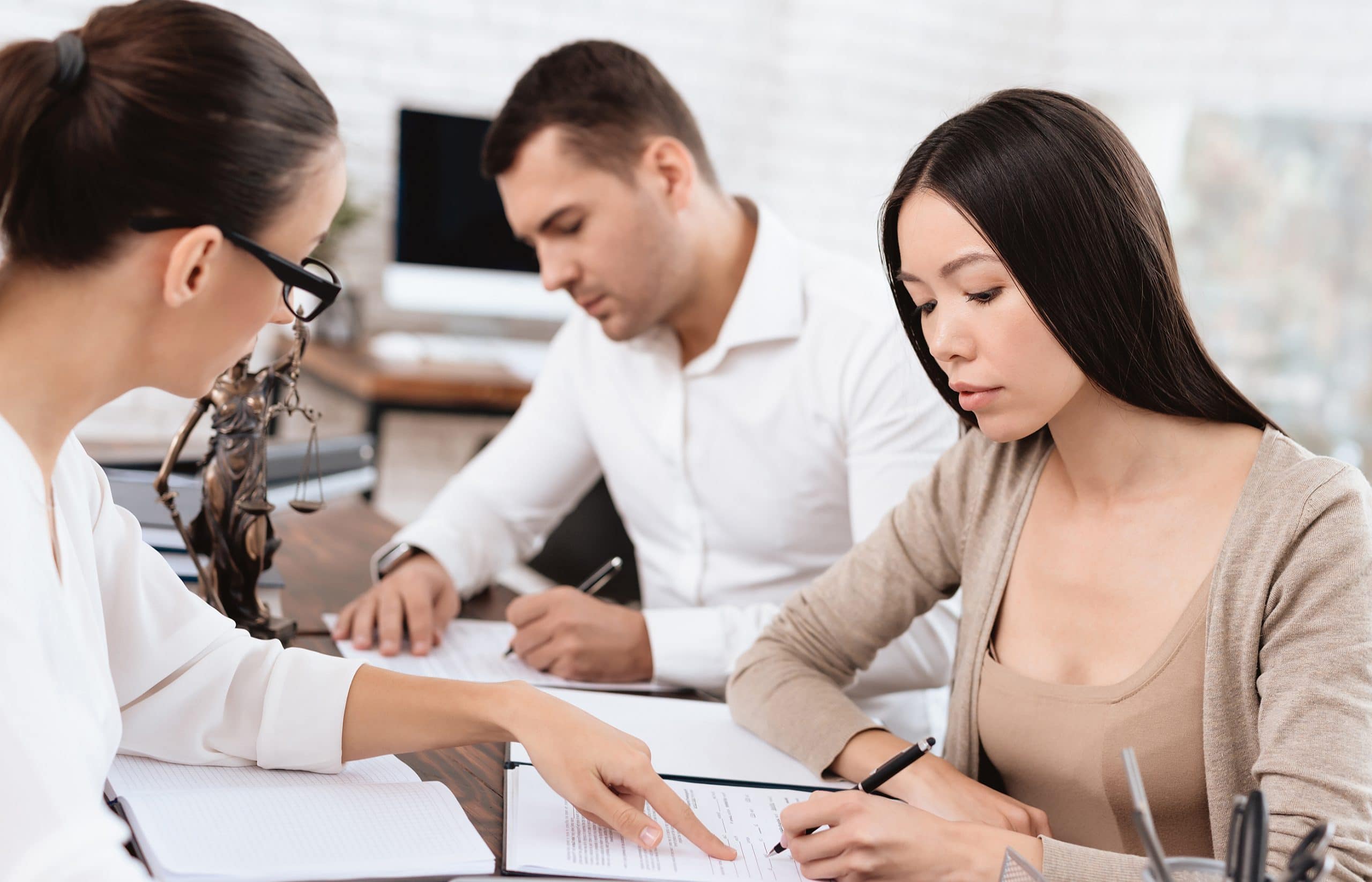 This is an image of a lawyer working with clients and agreeing on a settlement.