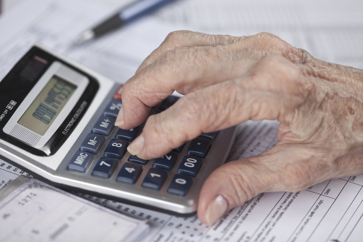 senior woman's hand doing financial work with calculator