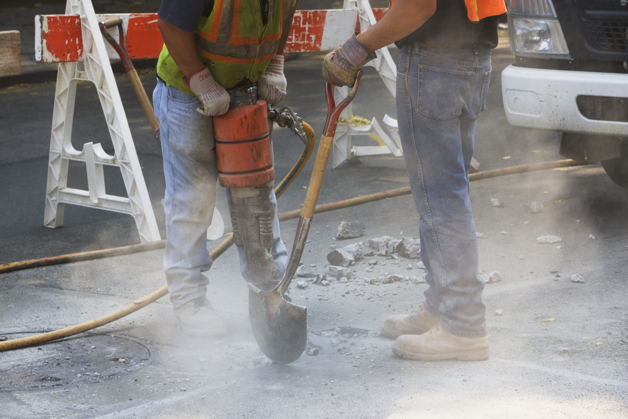 Construction workers using jackhammer and shovel