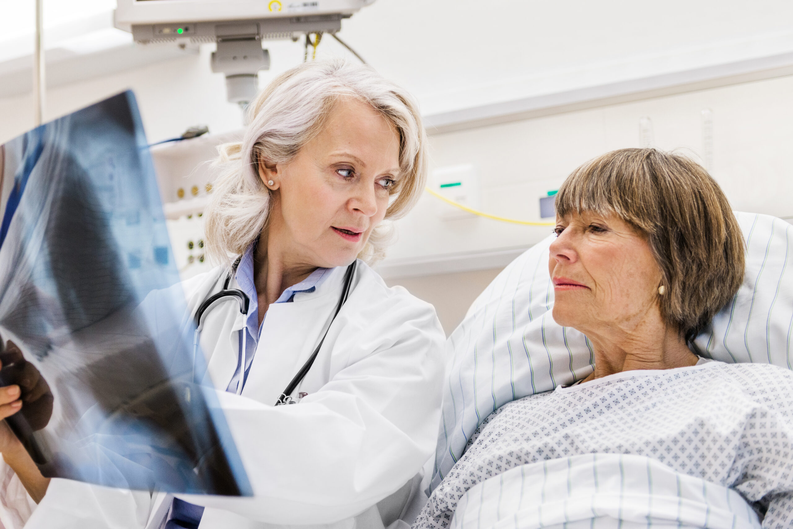 Elderly woman looking at lung x-rays with a doctor