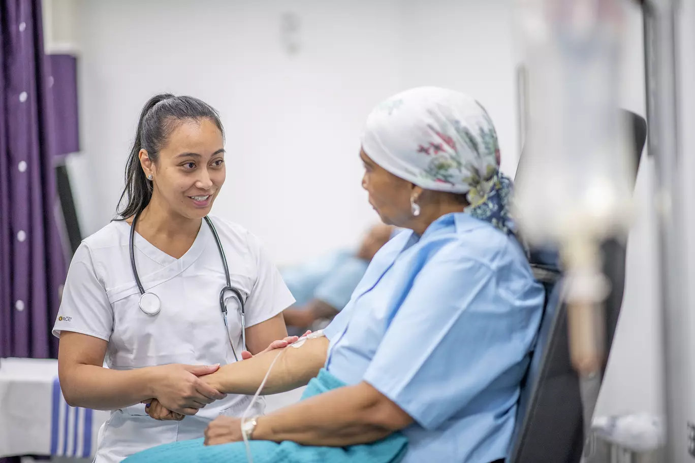 Female cancer patient wearing head scarf to cover hair loss while receiving chemotherapy treatment.