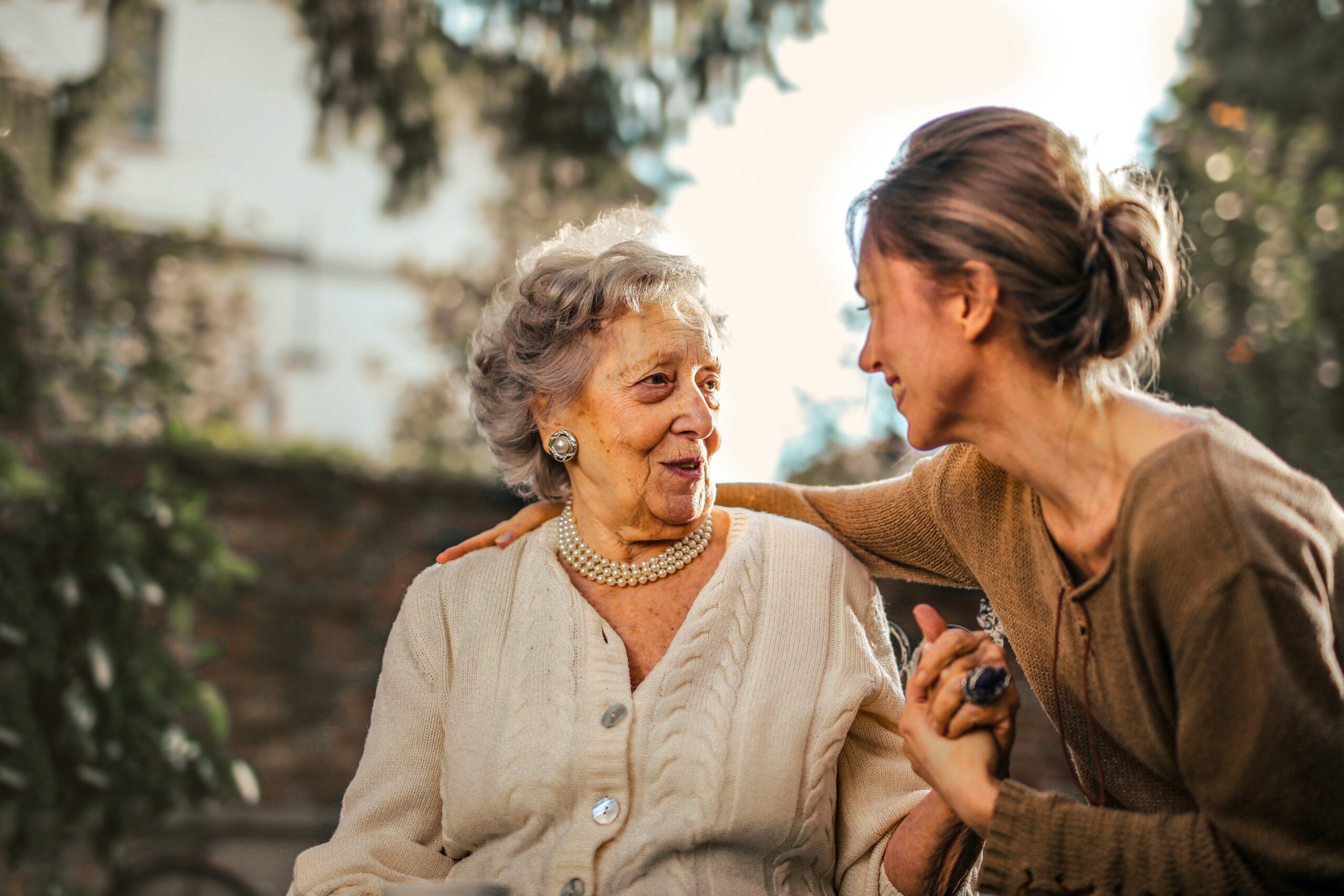 Young woman embracing mature woman outdoors