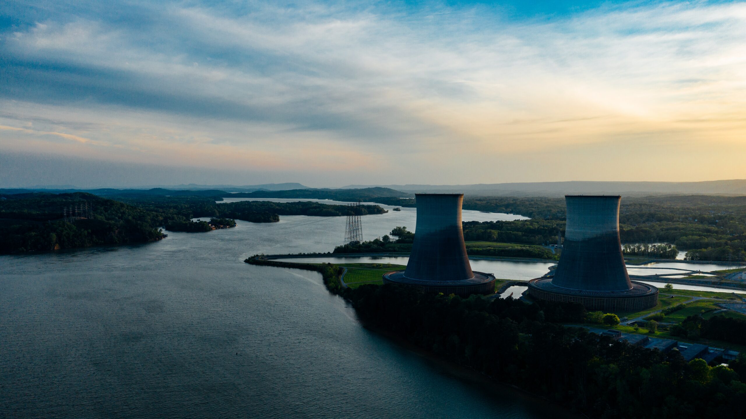 Two water treatment plants alongside river with sunset in background