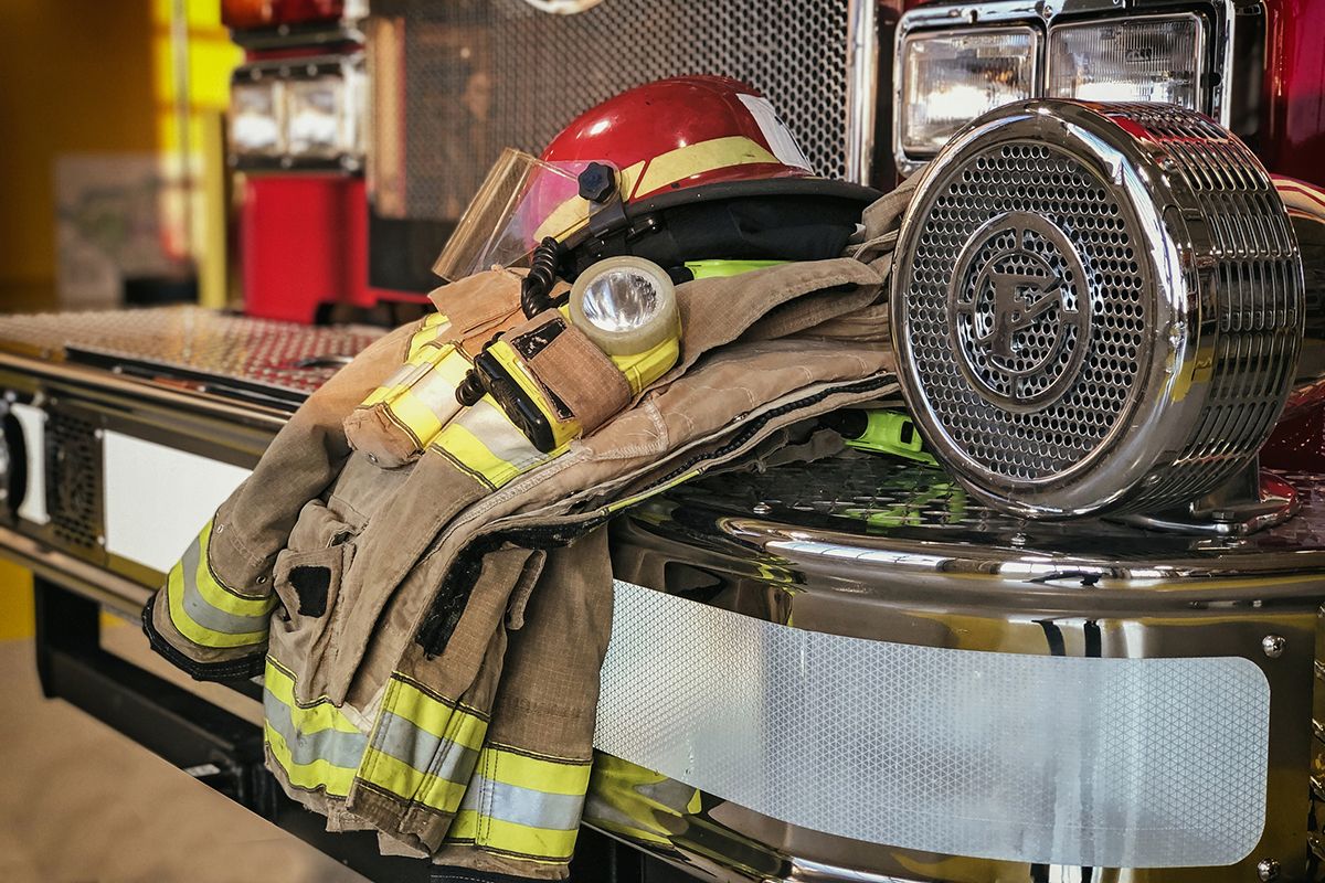 Firefighter protection clothes hanging off a fire trucks front